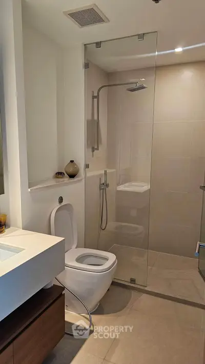Modern bathroom with glass shower enclosure and sleek fixtures