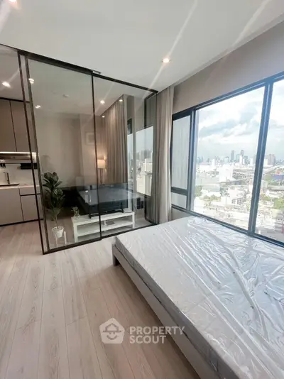 Modern bedroom with city view and glass partition to living area