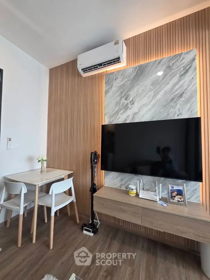 Modern living room with stylish wood paneling, marble accent wall, and sleek furniture.