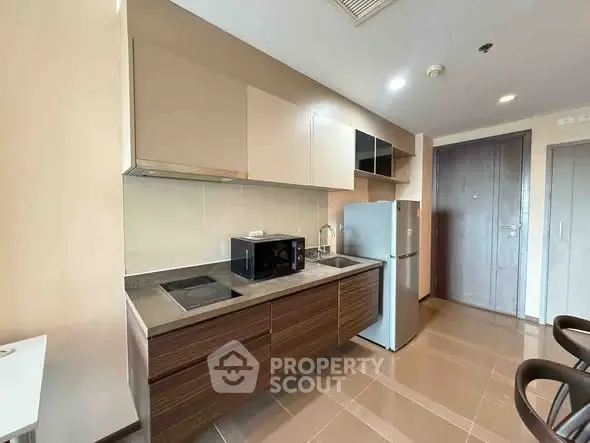 Modern kitchen with sleek cabinets, stainless steel appliances, and tiled flooring.