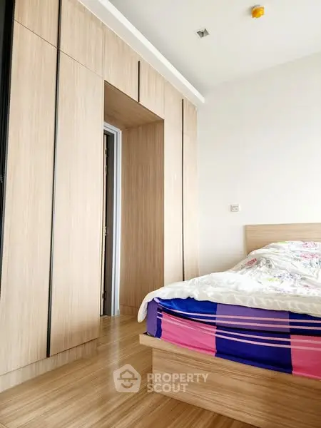 Modern bedroom with sleek wooden flooring and built-in wardrobe