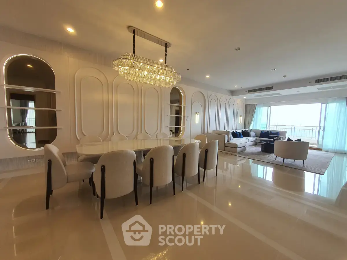 Luxurious open-plan living and dining area with elegant chandelier and modern furnishings.