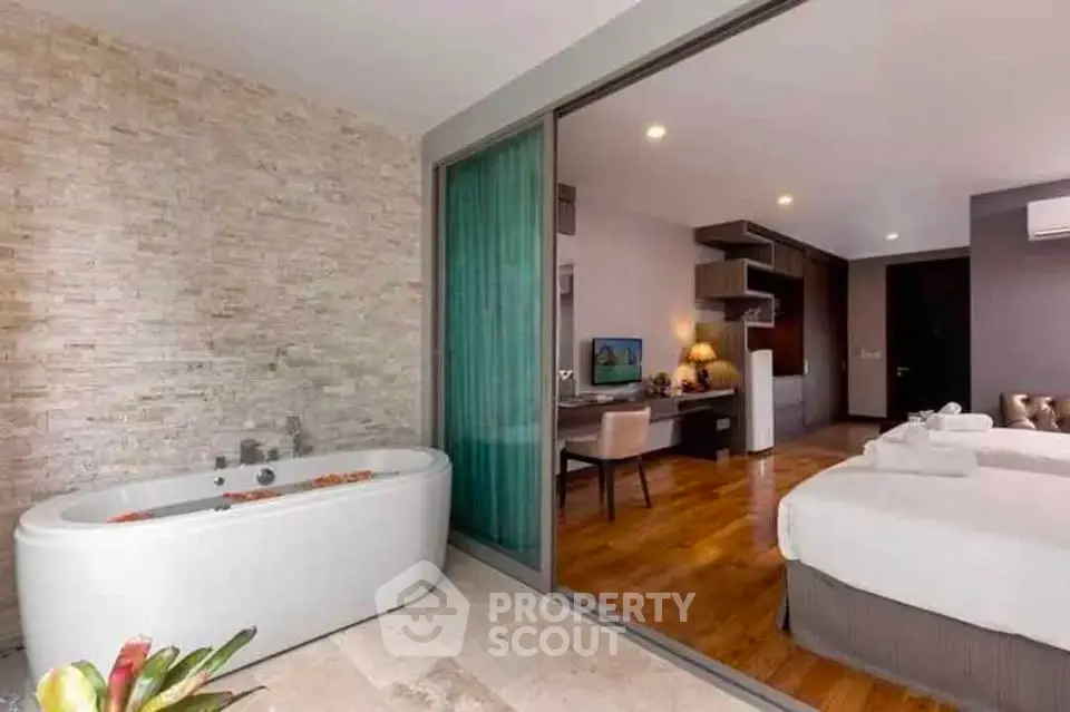 Luxurious hotel room with open layout featuring a bathtub and elegant decor.