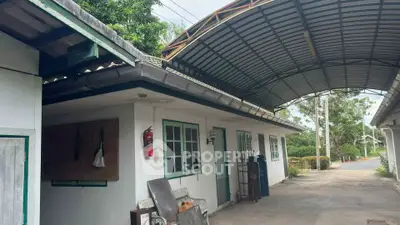 Charming single-story home with covered driveway and lush greenery, perfect for serene living.