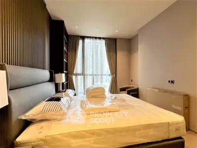 Luxurious bedroom with modern decor and large window offering city views.
