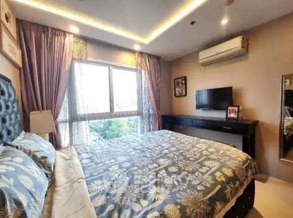 Luxurious bedroom with elegant decor and large window offering natural light.