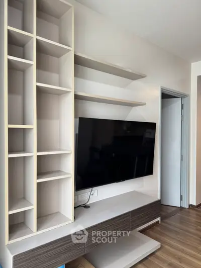 Modern living room with sleek TV unit and open shelving, perfect for stylish urban living.
