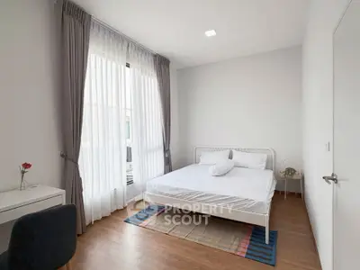 Bright and airy bedroom with modern decor and large window in a stylish apartment.