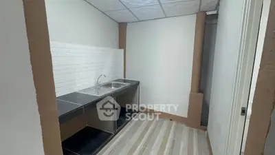 Compact kitchen with sleek black countertops and white tile backsplash
