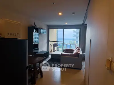 Modern living room with ocean view and cozy furniture in a high-rise apartment.