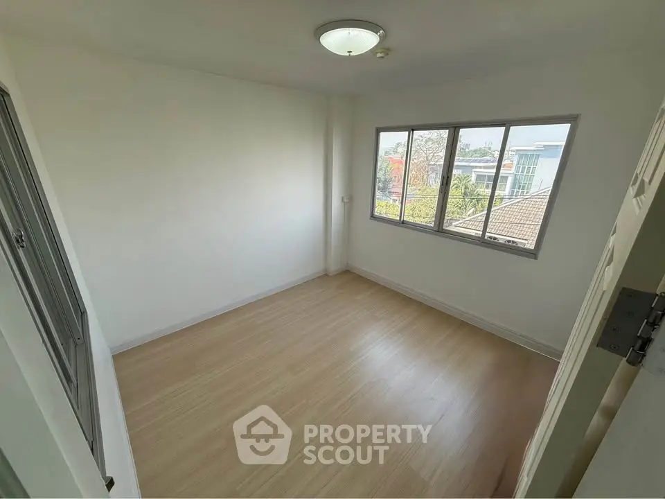 Spacious empty room with large windows and wooden flooring, perfect for customization.