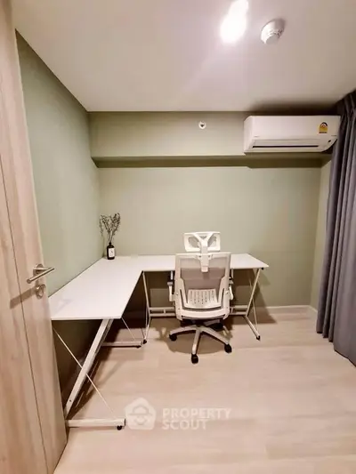 Modern study room with sleek desk and ergonomic chair, featuring minimalist decor and air conditioning.
