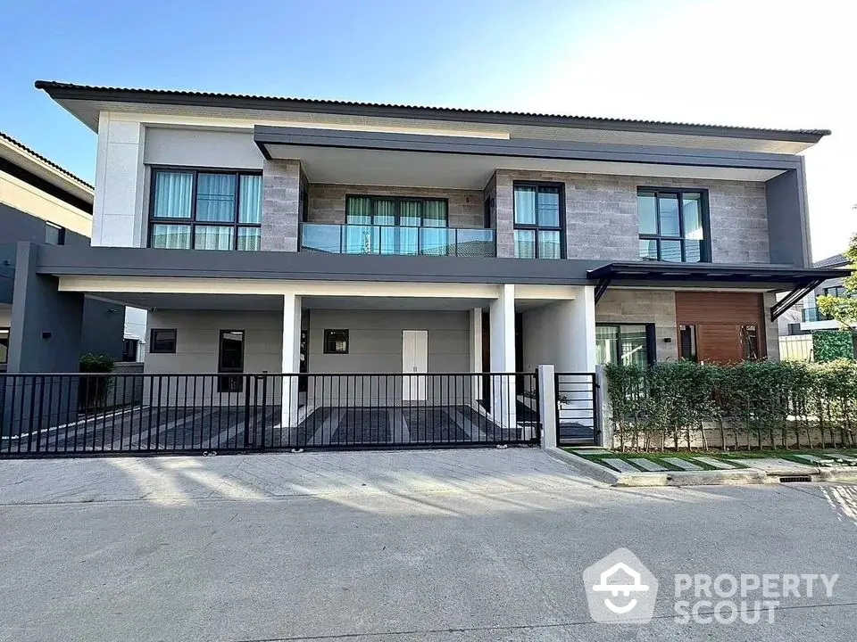 Modern two-story house with spacious driveway and sleek facade in a serene neighborhood.