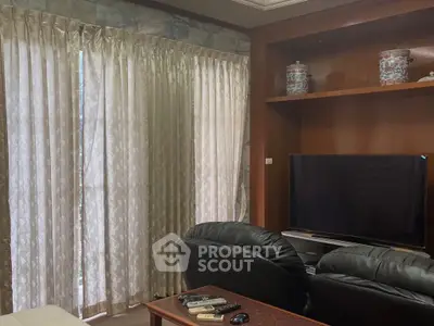 Cozy living room with leather seating and elegant curtains