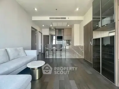 Modern open-layout living room with sleek kitchen and stylish furnishings
