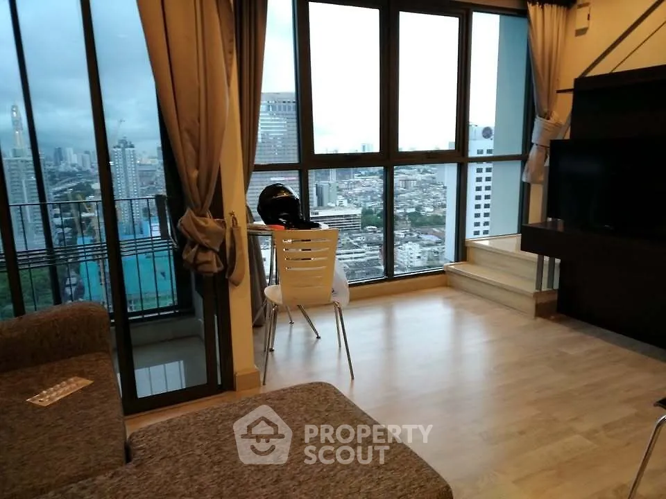 Modern living room with city view and balcony access in high-rise apartment