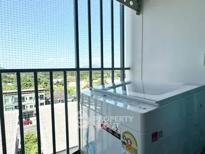 High-rise balcony with washing machine and scenic view of suburban landscape.