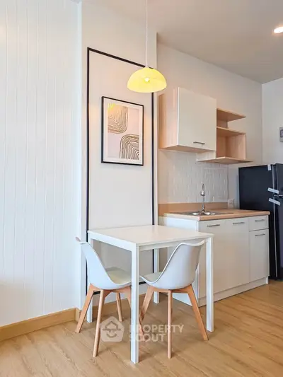 Modern kitchen with dining area, sleek cabinetry, and stylish decor
