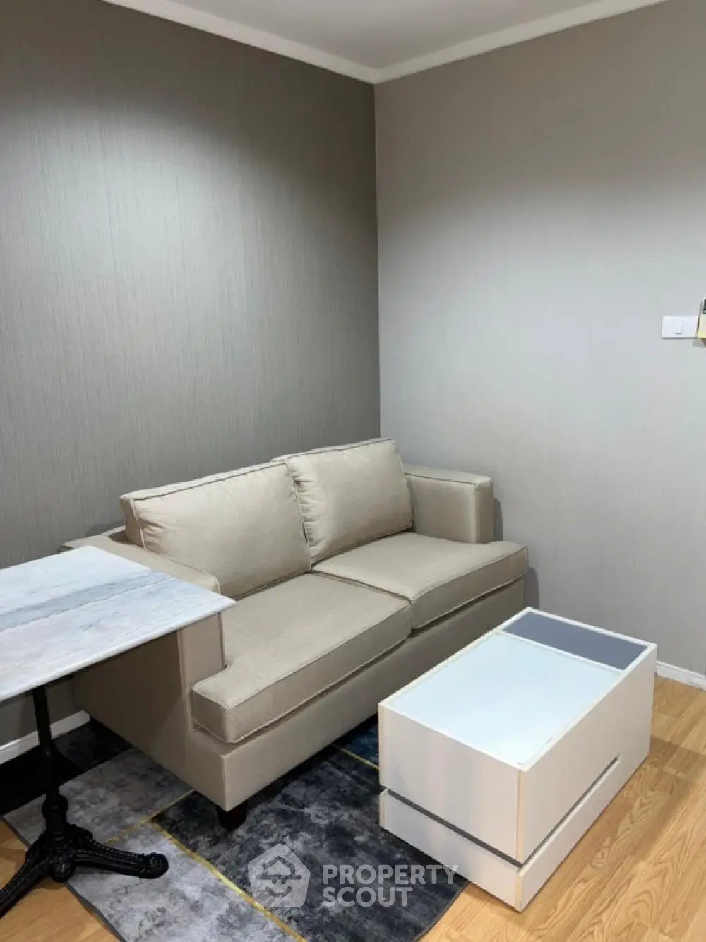 Cozy living room with modern beige sofa and sleek white coffee table.