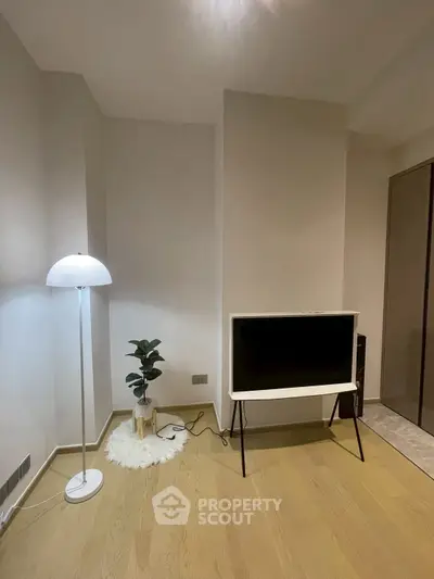 Modern minimalist living room with stylish floor lamp and sleek TV setup.