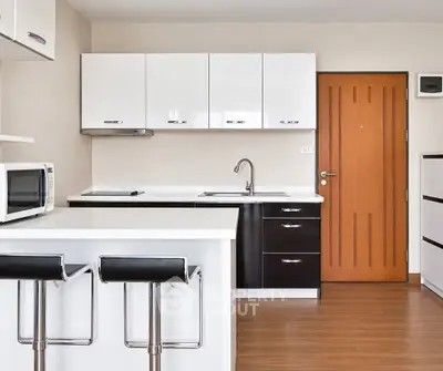 Modern kitchen with sleek cabinetry and breakfast bar in a stylish apartment.