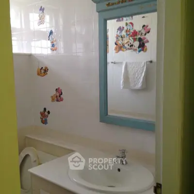 Charming bathroom with playful cartoon decor and modern sink in cozy home.