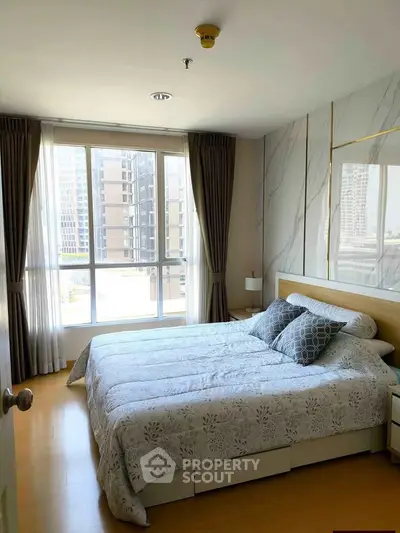 Bright and modern bedroom with large windows and stylish decor in urban apartment.