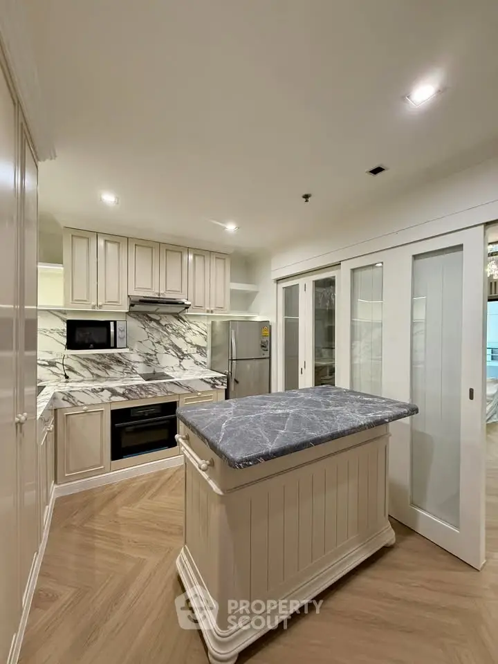 Luxurious kitchen with marble backsplash and island in modern apartment