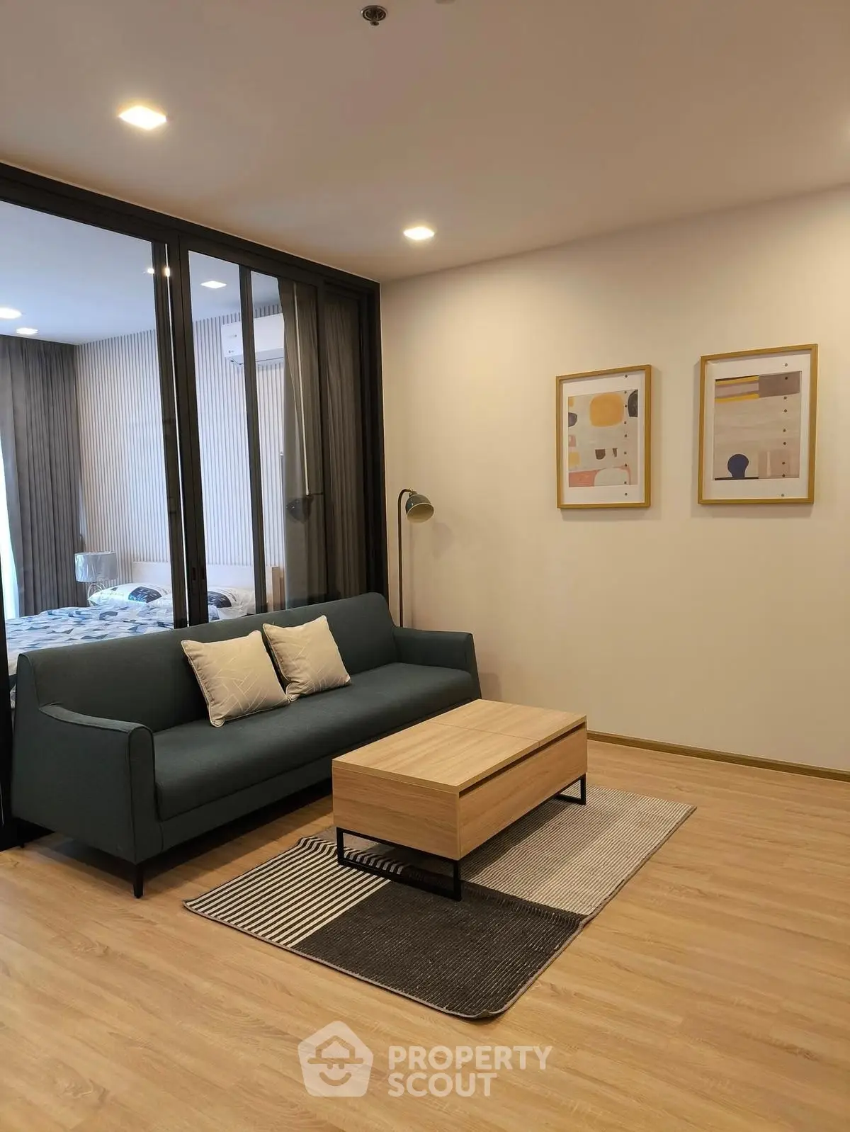 Modern living room with stylish sofa and coffee table, featuring elegant wall art and wooden flooring.