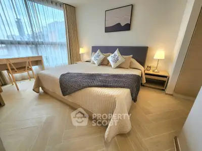 Elegant bedroom with modern decor, large window, and cozy ambiance in a stylish apartment.