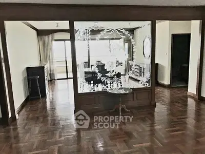 Spacious living room with elegant wooden flooring and large windows for natural light.