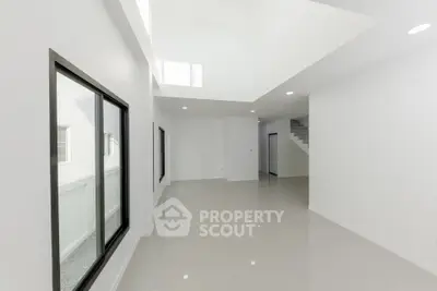 Spacious modern interior with high ceilings and large windows, perfect for natural light.