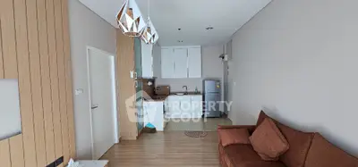 Modern living room with open kitchen layout and stylish lighting