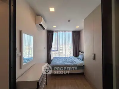 Modern bedroom with large window and city view, featuring sleek furniture and air conditioning.