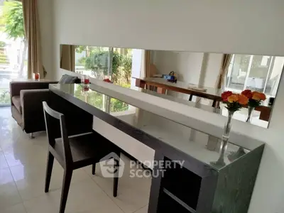 Elegant modern living room with sleek furniture and large mirror enhancing space and light.