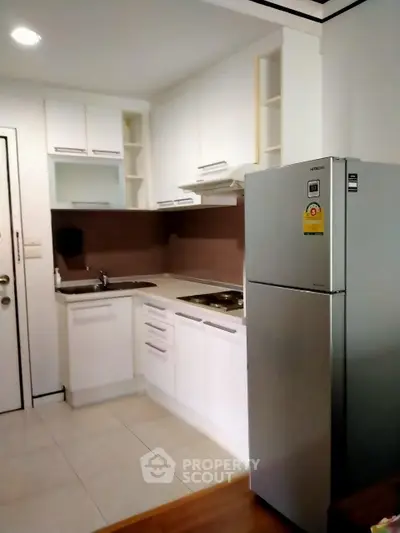 Modern kitchen with sleek white cabinets and stainless steel fridge