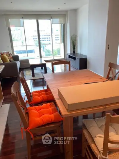 Spacious living room with dining area and large windows offering city views.