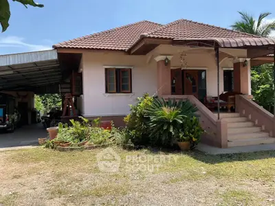 Charming single-story house with a spacious carport and lush garden in a serene neighborhood.