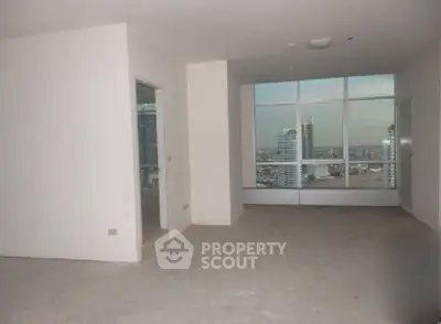 Spacious modern apartment with large windows offering stunning city views.