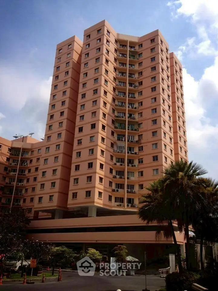 Stunning high-rise residential building with lush landscaping and clear blue sky.