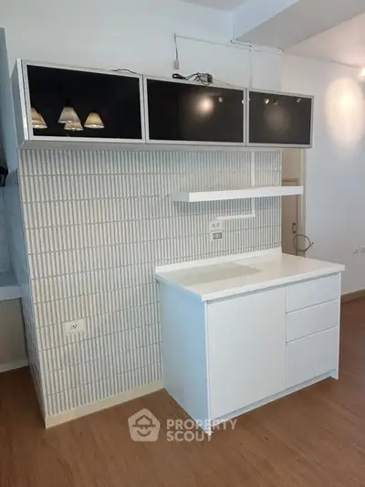 Modern kitchen with sleek cabinetry and stylish backsplash in a contemporary apartment.
