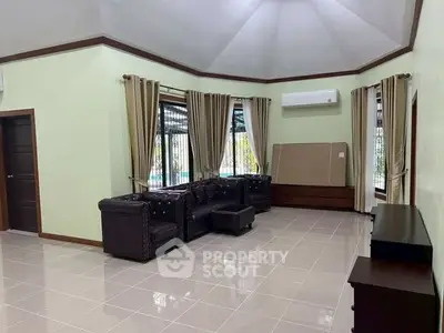 Spacious living room with elegant leather sofas and large windows