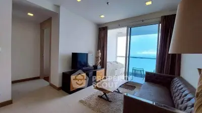 Modern living room with ocean view balcony, stylish furniture, and natural light.