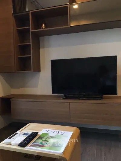 Modern living room with sleek wooden furniture and flat-screen TV