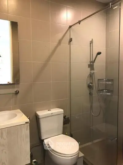 Modern bathroom with glass shower and sleek fixtures in a contemporary home.