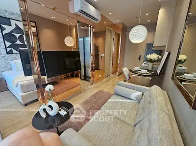 Modern living room with stylish decor and open layout, featuring a cozy sofa and elegant lighting.