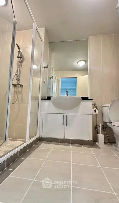 Modern bathroom with sleek shower and elegant vanity in contemporary apartment.