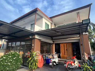 Modern two-story house with covered parking and lush greenery