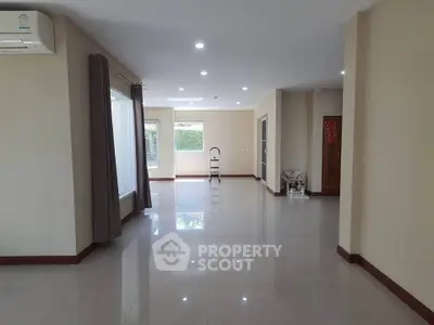 Spacious open-plan living area with large windows and modern lighting