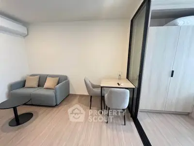 Modern living room with cozy sofa, sleek table, and stylish chairs in a minimalist apartment.